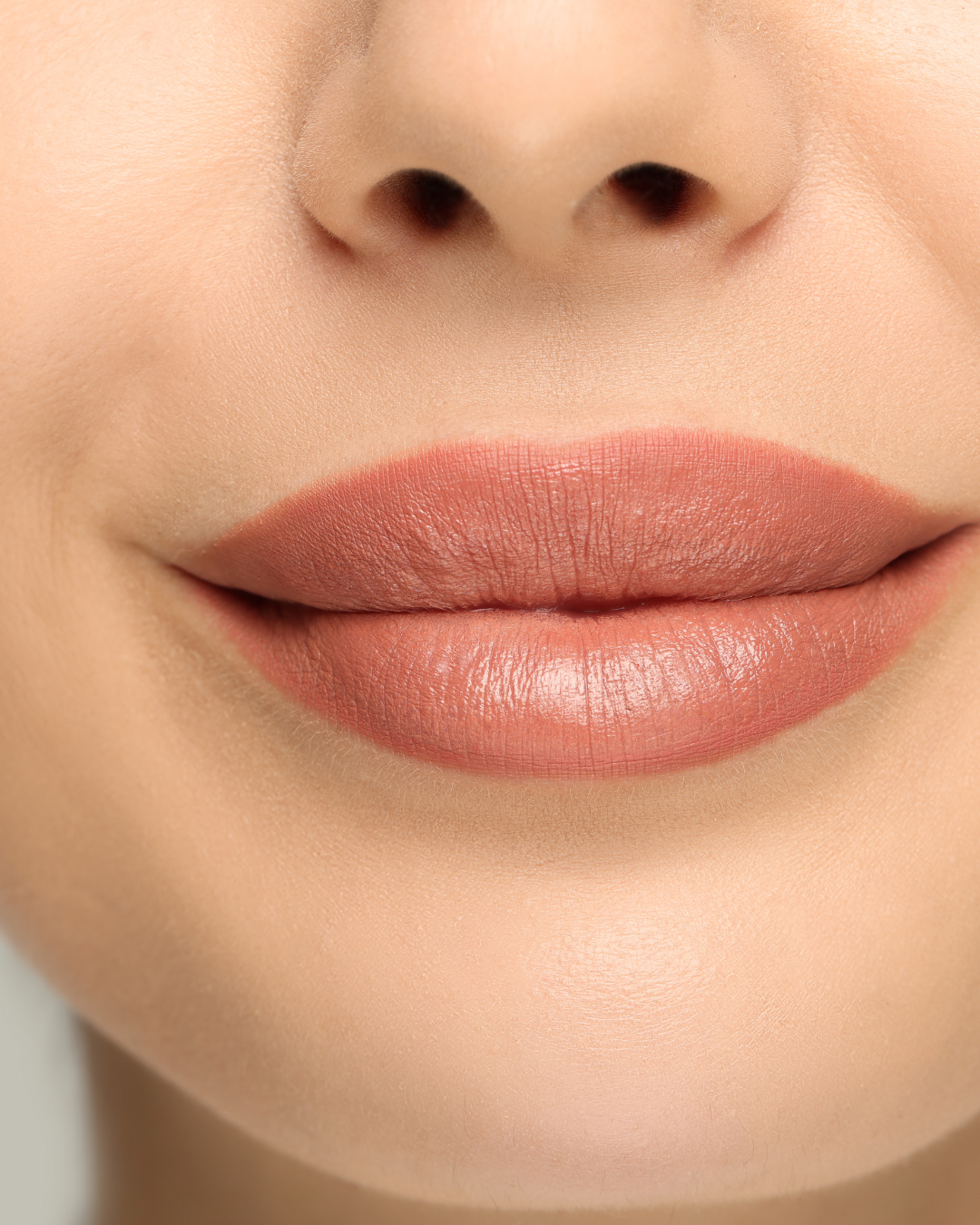 A woman wearing a stunning blend of Naked Peach and Dhalia shades on her lips. The combination of the soft nude and bold Dhalia creates a unique, layered look that enhances her natural beauty with a touch of elegance and sophistication.